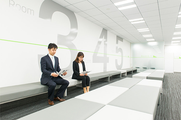 試験会場へ受験生二人が入ろうとしている様子の写真。試験監督員がドアの脇に立っている。